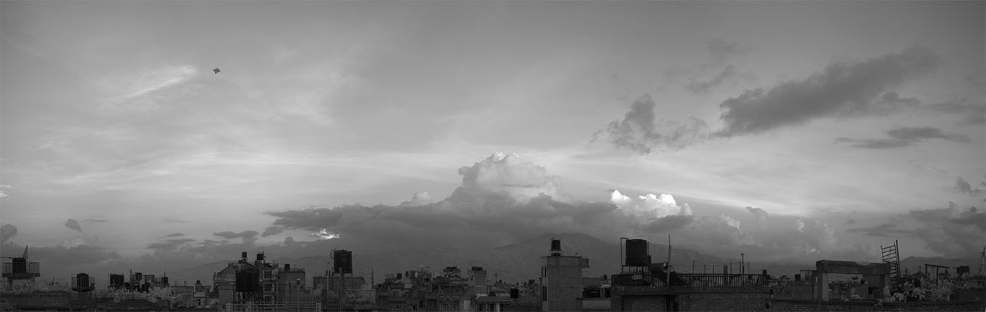 Moody Infrared Panorama of Cityscape at Dusk, with a Small Kite High Above.